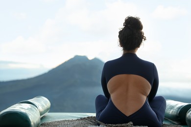 Photo of Beautiful woman enjoying picturesque view of mountains, back view. Space for text