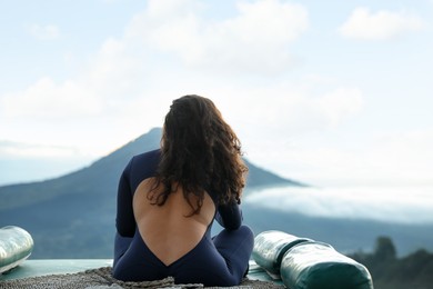 Photo of Beautiful woman enjoying picturesque view of mountains, back view