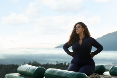 Photo of Beautiful woman enjoying picturesque view of mountains. Space for text