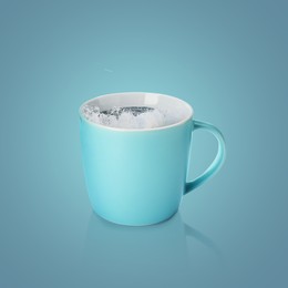 Image of Sea wave splashing out of ceramic cup on pastel blue background