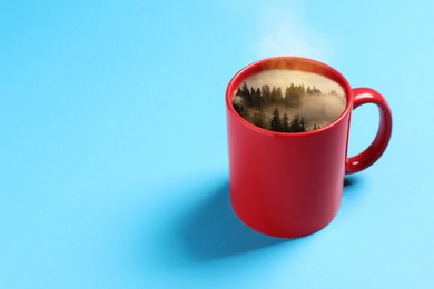 Image of Misty mountain forest in red cup on light blue background