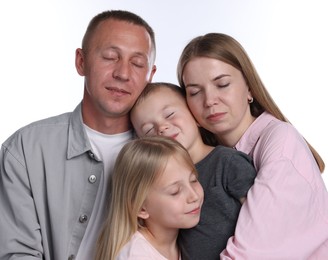 Photo of Cute family with closed eyes posing on white background