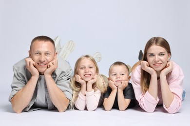 Photo of Family portrait of happy parents and their children on light grey background