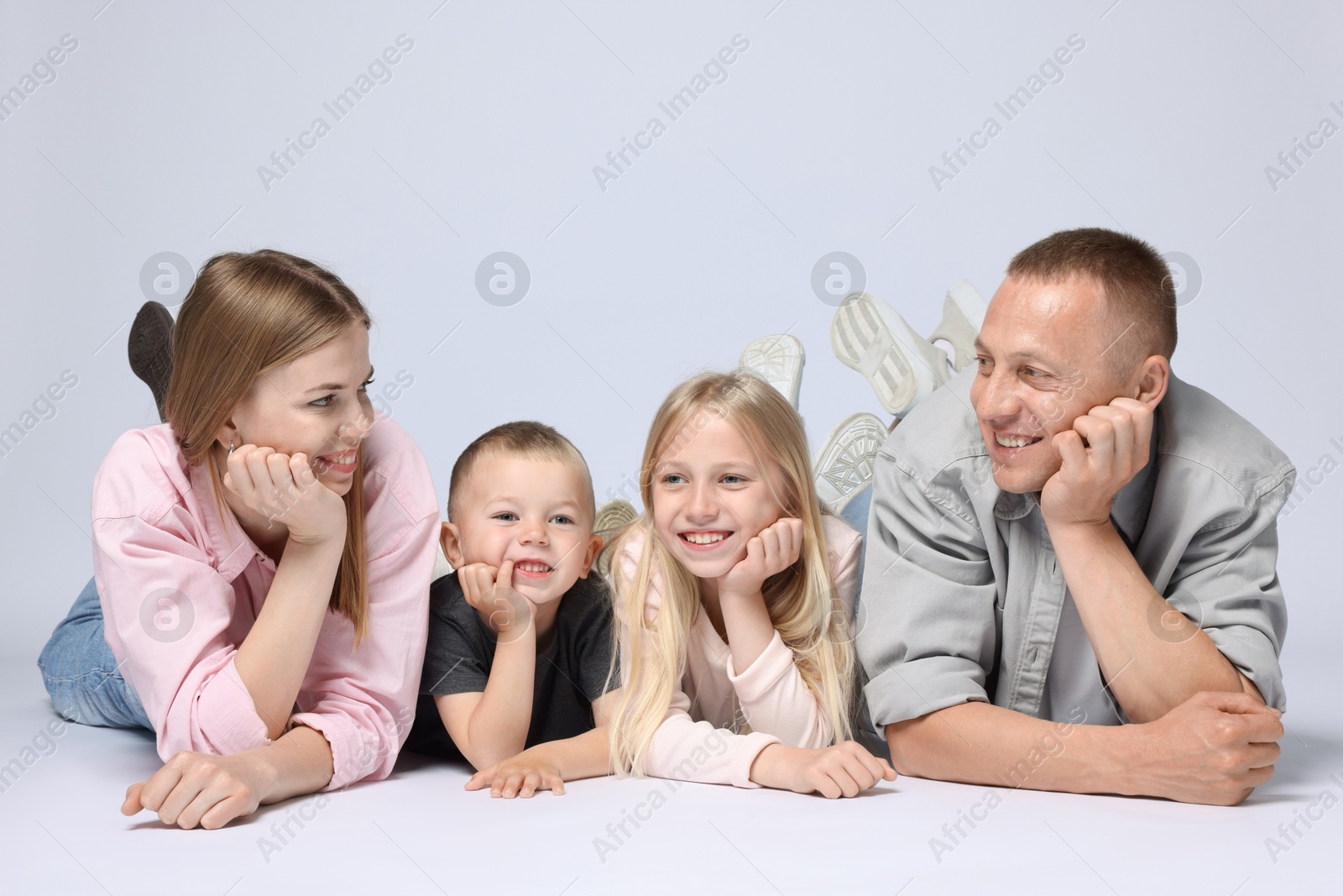 Family portrait of happy parents and their children on light grey background Photo of Family portrait of happy parents and their children on light grey background