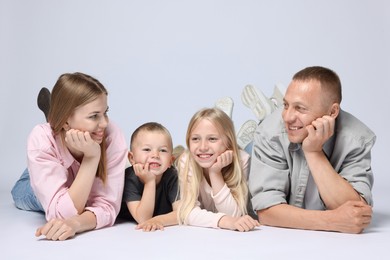 Photo of Family portrait of happy parents and their children on light grey background
