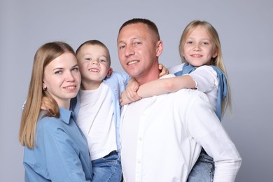 Photo of Family portrait of happy parents and their children on grey background