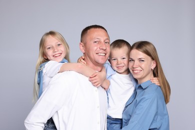 Photo of Family portrait of happy parents and their children on grey background