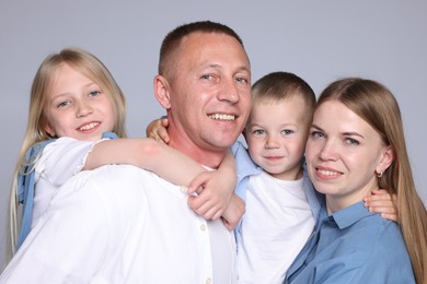 Photo of Family portrait of happy parents and their children on grey background