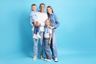 Photo of Full length portrait of happy family on light blue background