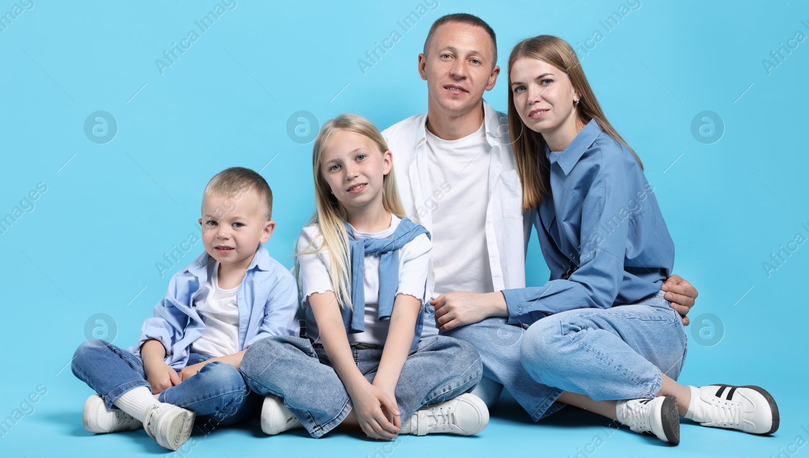 Full length portrait of happy family on light blue background Photo of Full length portrait of happy family on light blue background