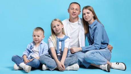 Photo of Full length portrait of happy family on light blue background