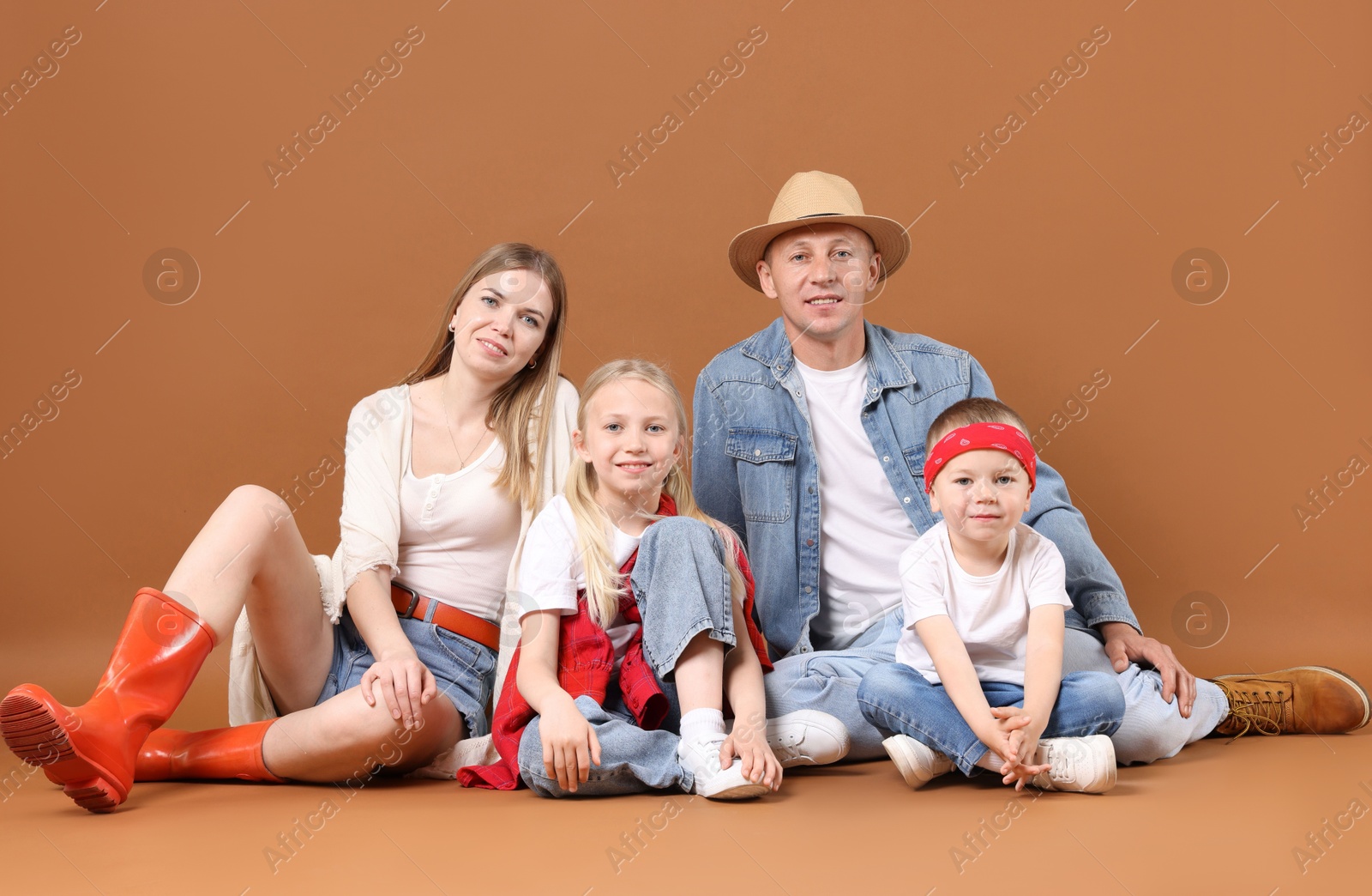 Photo of Full length portrait of happy family on light brown background