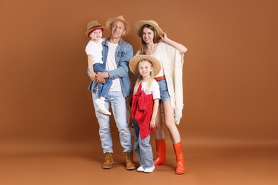 Photo of Full length portrait of happy family in hats on light brown background