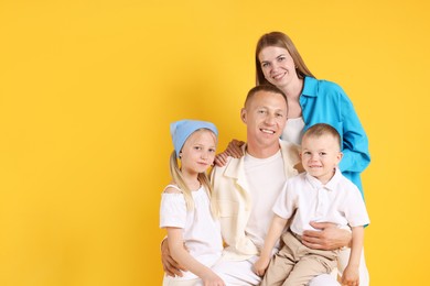 Photo of Happy family on yellow background. Space for text