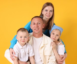 Photo of Family portrait of happy parents and their children on yellow background
