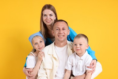 Photo of Family portrait of happy parents and their children on yellow background