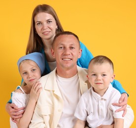 Photo of Family portrait of happy parents and their children on yellow background