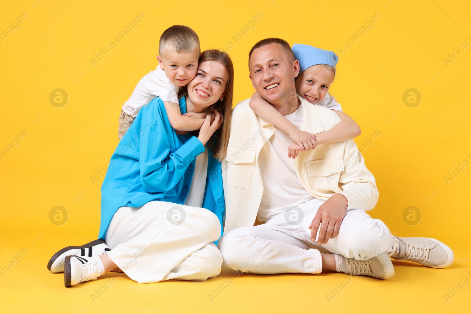 Full length portrait of happy family on yellow background Photo of Full length portrait of happy family on yellow background