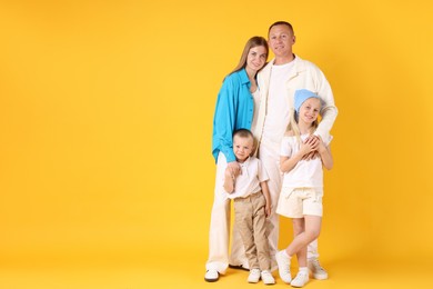 Photo of Full length portrait of happy family on yellow background. Space for text