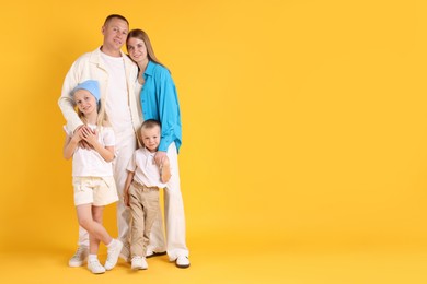 Photo of Full length portrait of happy family on yellow background. Space for text