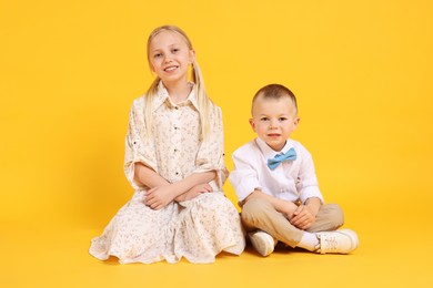 Photo of Happy brother and sister on yellow background