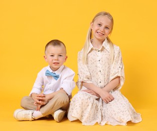 Photo of Happy brother and sister on yellow background