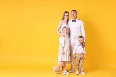 Photo of Full length portrait of happy family on yellow background. Space for text