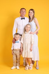 Photo of Full length portrait of happy family on yellow background