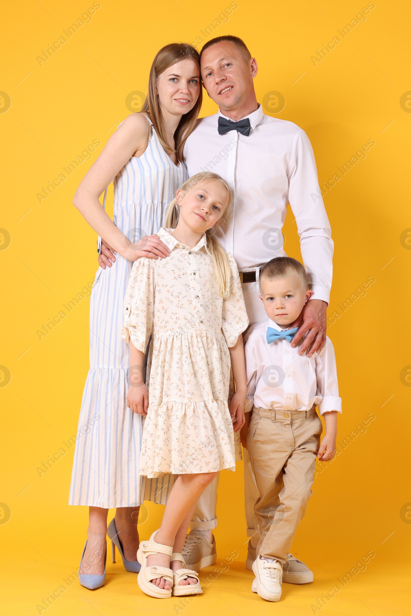 Full length portrait of happy family on yellow background Photo of Full length portrait of happy family on yellow background