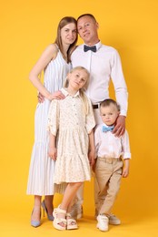 Photo of Full length portrait of happy family on yellow background