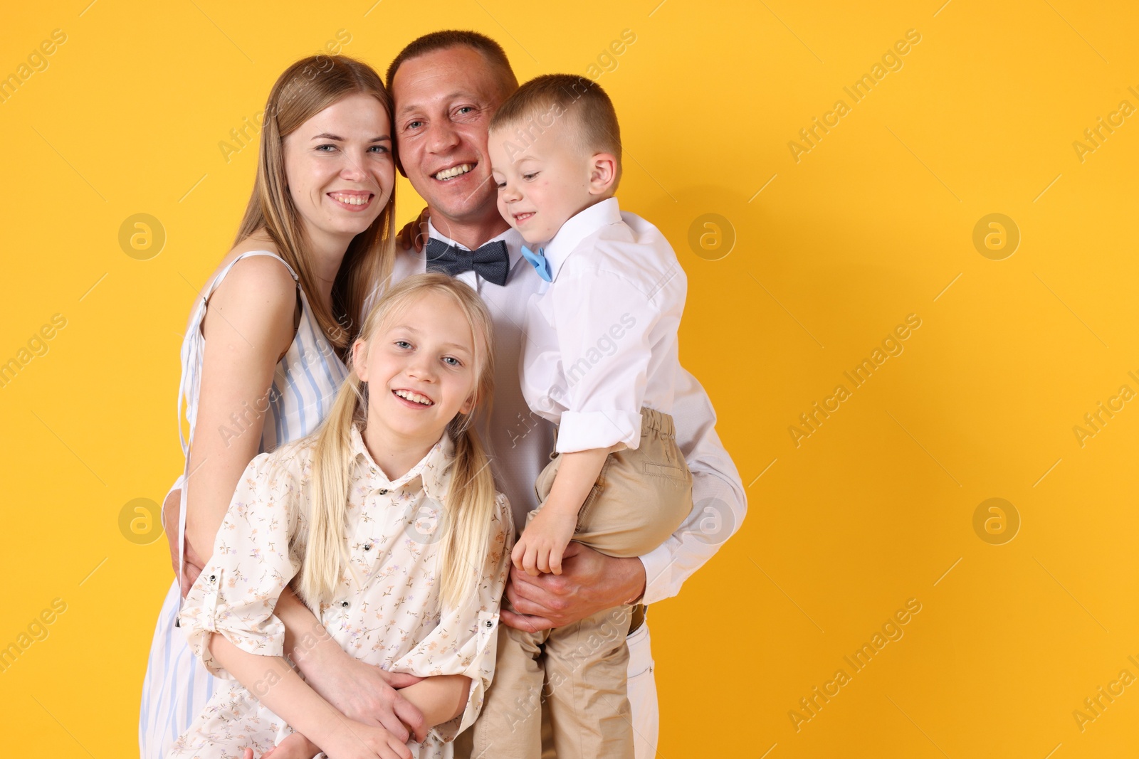 Happy family on yellow background. Space for text Photo of Happy family on yellow background. Space for text