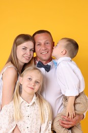 Photo of Family portrait of happy parents and their children on yellow background
