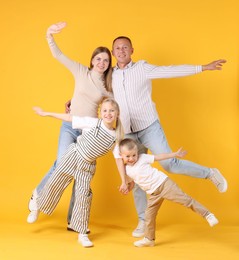 Photo of Full length portrait of happy family on yellow background