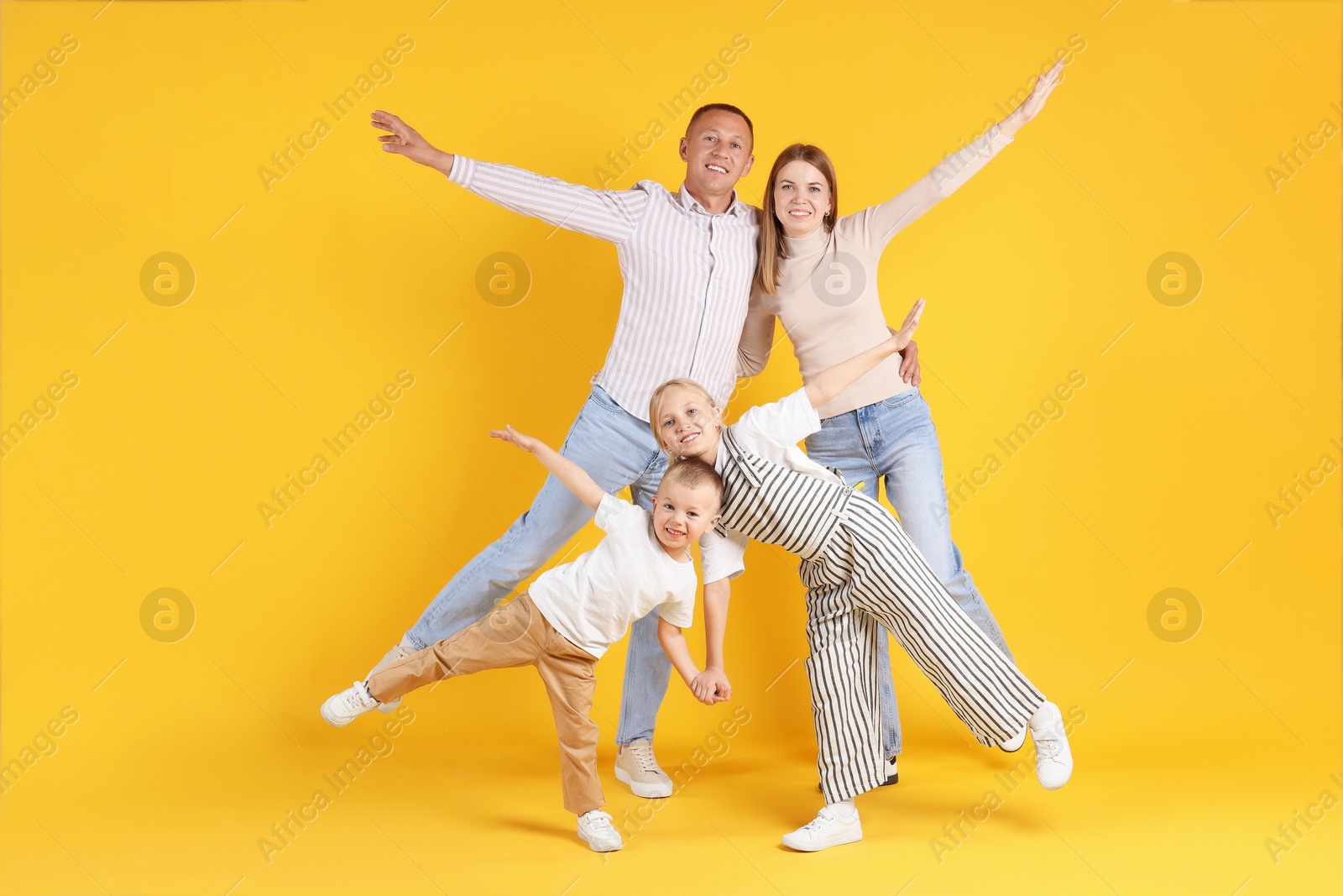 Photo of Full length portrait of happy family on yellow background