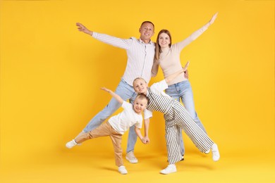 Photo of Full length portrait of happy family on yellow background