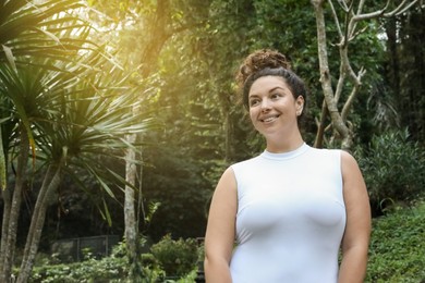 Photo of Happy woman in tropical forest, space text copy