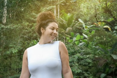 Photo of Happy woman in tropical forest, space text copy