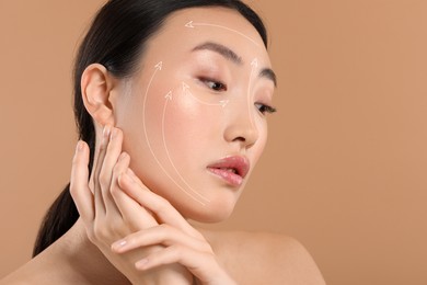 Image of Beautiful woman with perfect skin after collagen treatment on light brown background, space for text. Arrows on her face illustrating lifting and smoothing effect