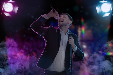 Image of Young handsome man singing at open air festival