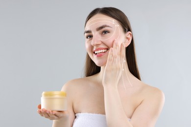 Image of Beautiful woman applying collagen cream onto face on grey background. Arrows on her face illustrating lifting and smoothing effect