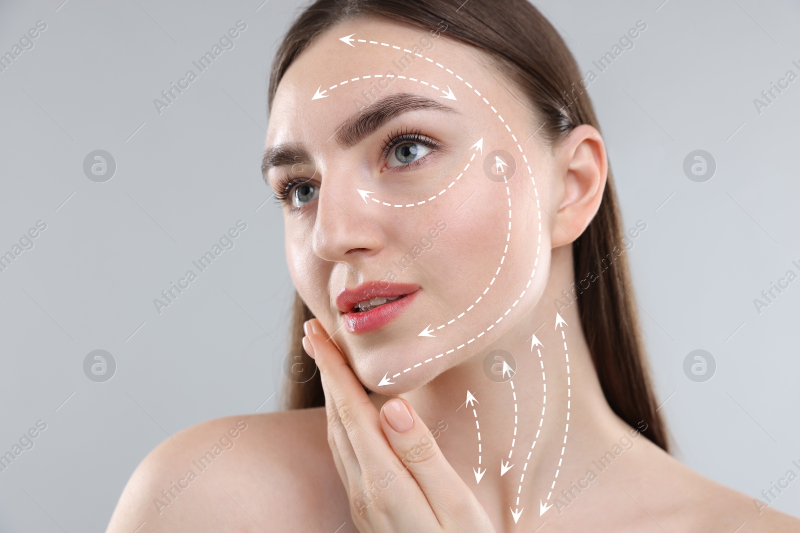 Beautiful woman with perfect skin after collagen treatment on grey background. Arrows on her face illustrating lifting and smoothing effect Image of Beautiful woman with perfect skin after collagen treatment on grey background. Arrows on her face illustrating lifting and smoothing effect