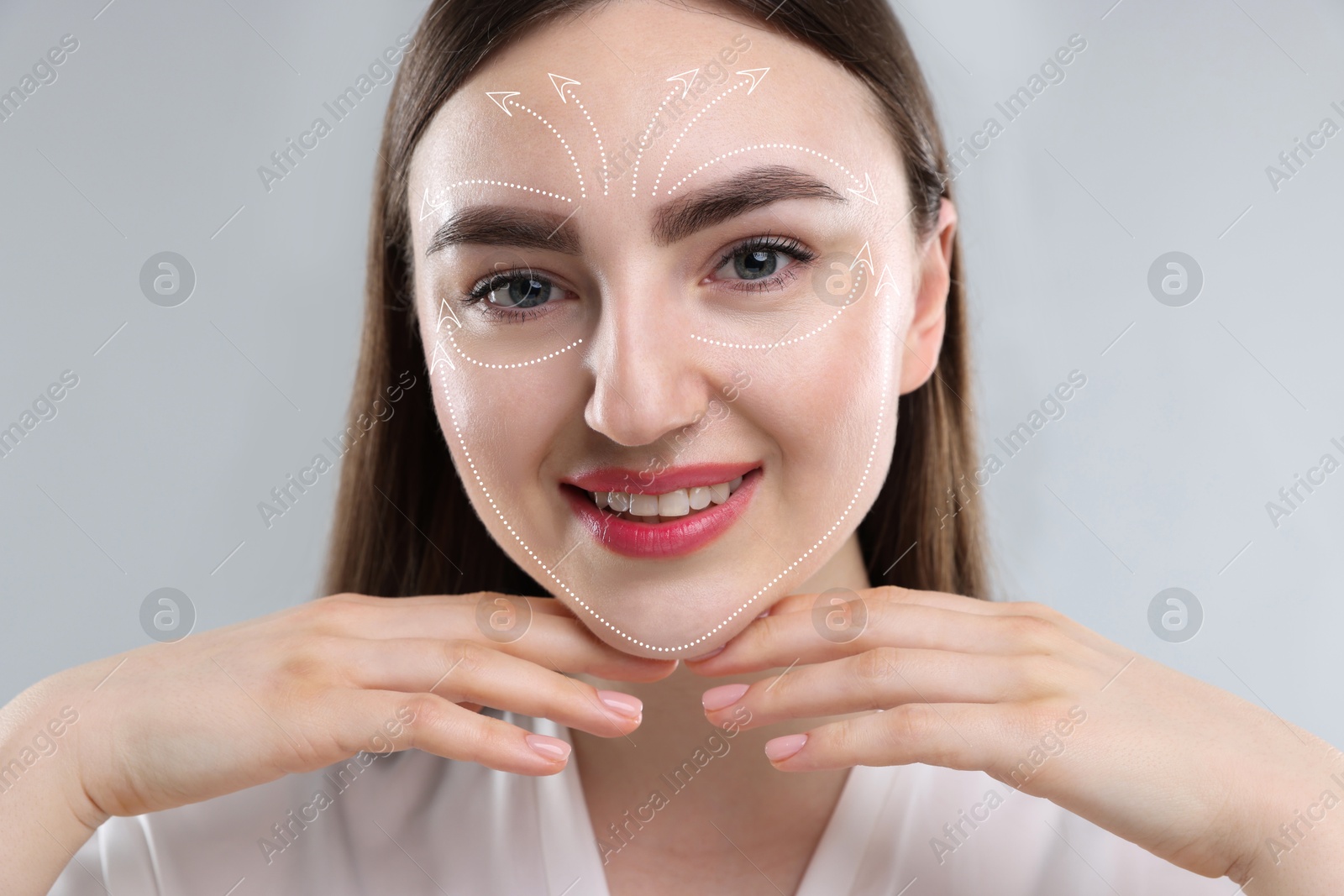 Beautiful woman with perfect skin after collagen treatment on grey background. Arrows on her face illustrating lifting and smoothing effect Image of Beautiful woman with perfect skin after collagen treatment on grey background. Arrows on her face illustrating lifting and smoothing effect