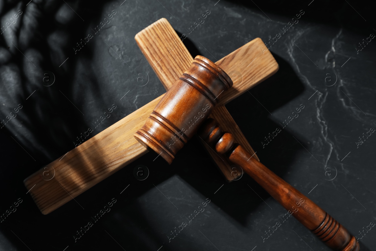 Judge's gavel and wooden cross on black table, top view Photo of Judge's gavel and wooden cross on black table, top view