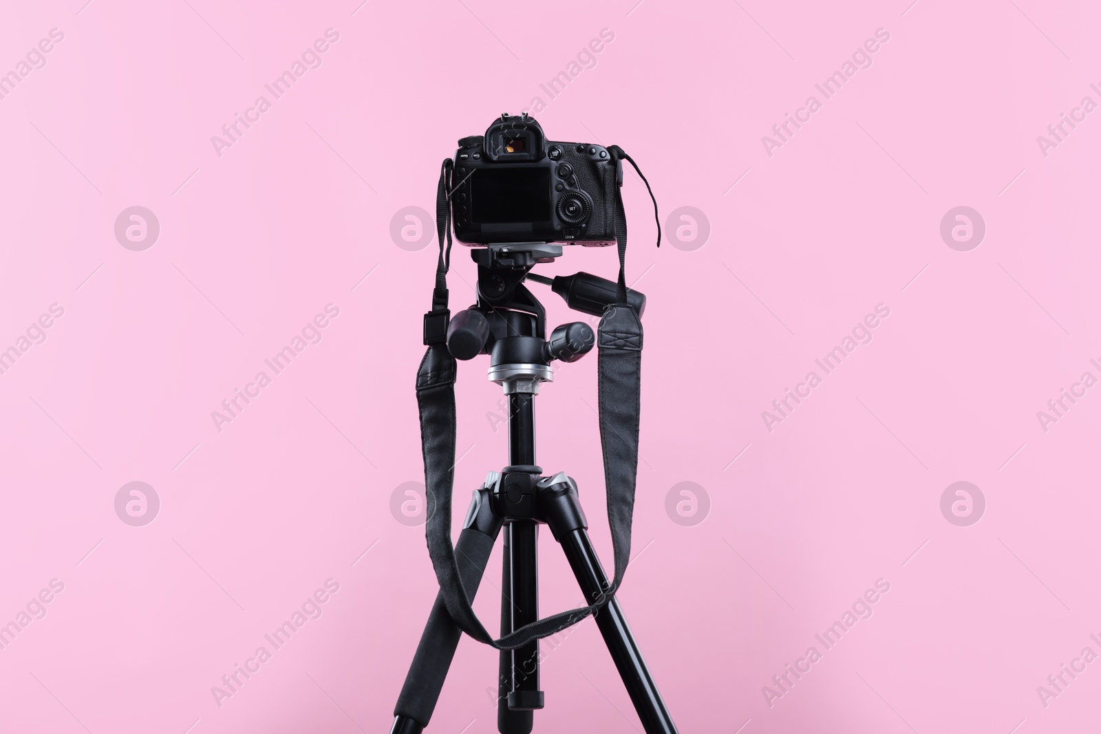 Modern professional video camera on pink background Photo of Modern professional video camera on pink background