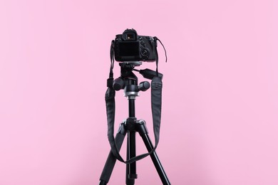Photo of Modern professional video camera on pink background