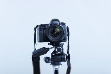 Photo of Modern professional video camera on light grey background, closeup