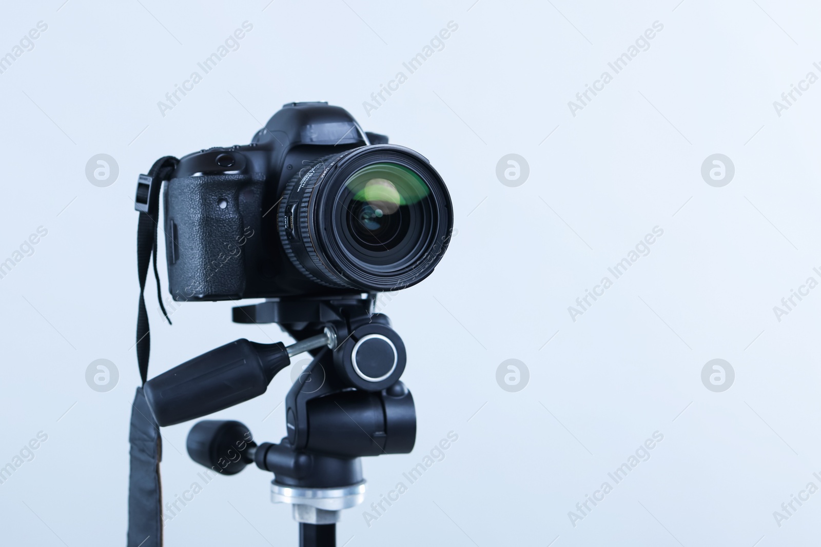 Modern professional video camera on light grey background, closeup. Space for text Photo of Modern professional video camera on light grey background, closeup. Space for text