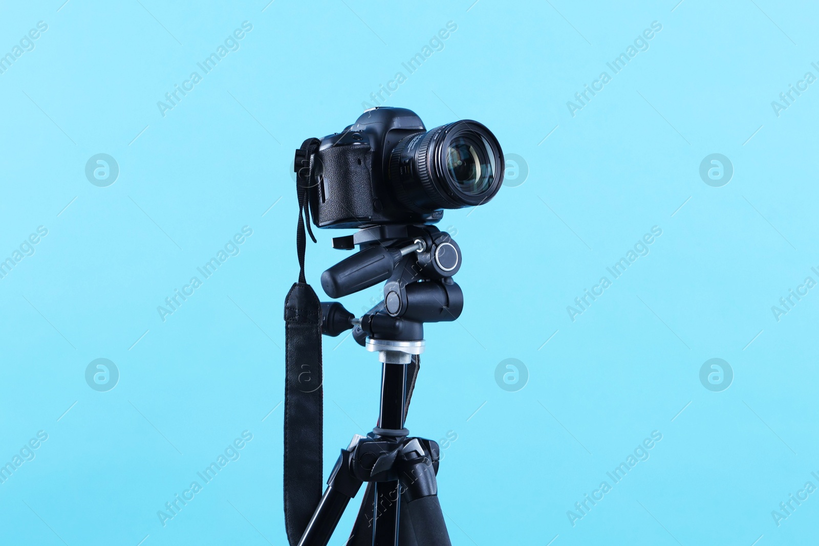Professional video camera on light blue background Photo of Professional video camera on light blue background