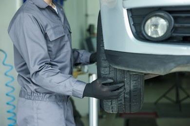 Photo of Mechanic changing tire at car service, closeup