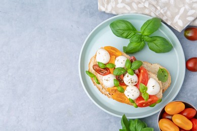 Photo of Tasty sandwich with mozzarella cheese, tomatoes and basil on grey table, flat lay. Space for text
